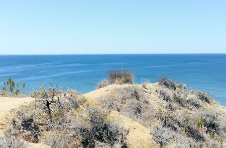 Peaceful coastal sunshine beach with hillside over ocean view natural background. Sunny dream holiday destinationの写真素材