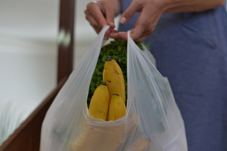 Closeup of modern elegant stylish adult woman buyer holding shopping purchase bag on the street background. Busy consumerism spending lifestyleの写真素材