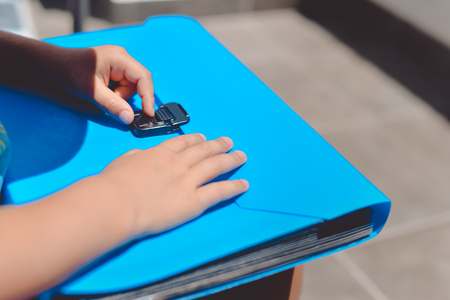 Close up on schoolchild holding plastic folder, abstract educational background. Top side view imageの写真素材