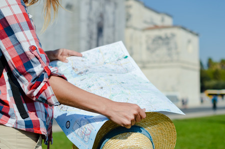 Close up detail of tourist traveler hands holding city map on sunny day outdoors background. Person...