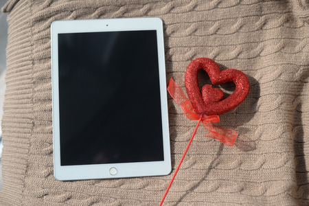 Los Angeles, USA - 27 May 2017: Apple Ipad 2 and red love heart on handmade woolen background. Modern digital information communication technologyの写真素材