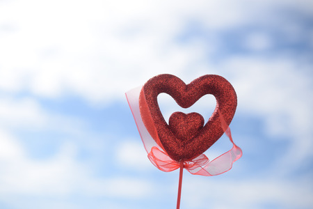 Closeup on red love heart over light blue sky backgroundの写真素材