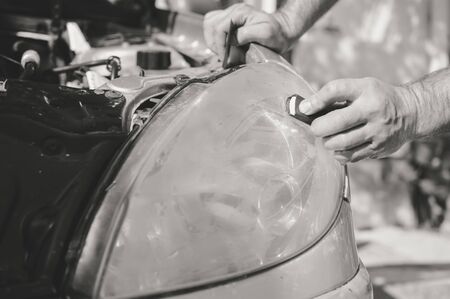 Automobile industry. Close up on car detail - male hand polish in auto repair shop background. Professional person during mechanical maintenance, industrial part transport renovationの写真素材