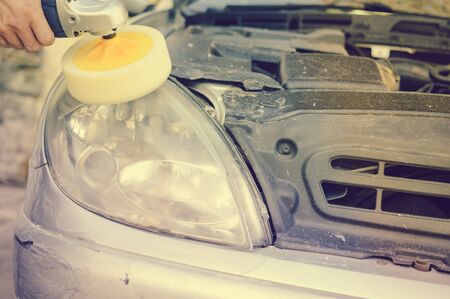 Automobile industry. Close up on car detail - male hand polish in auto repair shop background. Professional person during mechanical maintenance, industrial part transport renovationの写真素材