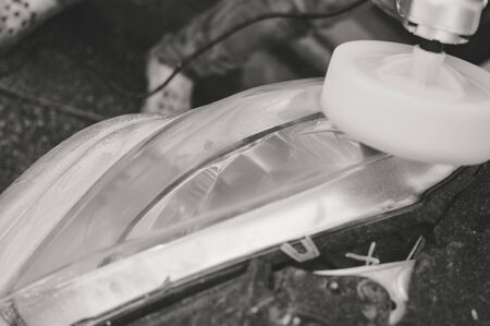 Automobile industry. Close up on car detail - male hand polish in auto repair shop background. Professional person during mechanical maintenance, industrial part transport renovationの写真素材