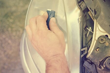 Automobile industry. Close up on car detail - male hand polish in auto repair shop background. Professional person during mechanical maintenance, industrial part transport renovationの写真素材