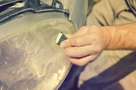Automobile industry. Close up on car detail - male hand polish in auto repair shop background. Professional person during mechanical maintenance, industrial part transport renovationの写真素材