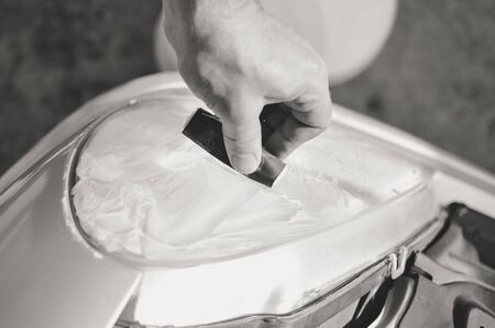 Automobile industry. Close up on car detail - male hand polish in auto repair shop background. Professional person during mechanical maintenance, industrial part transport renovationの写真素材