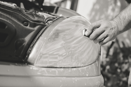 Automobile industry. Close up on car detail - male hand polish in auto repair shop background. Professional person during mechanical maintenance, industrial part transport renovationの写真素材
