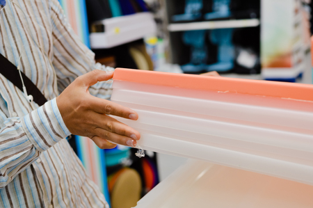 Close up image of person choosing selecting container on the indoors background. Buying, checking,...