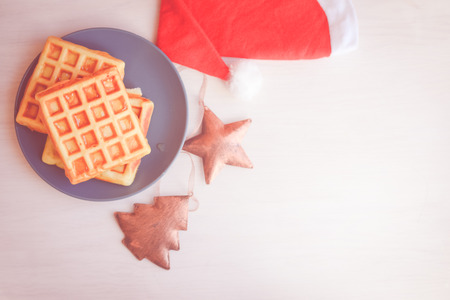Winter style delicious pastries. Closeup of waffles on light table background. Top side view on tasty natural decoration. Xmas classic lifestyleの写真素材