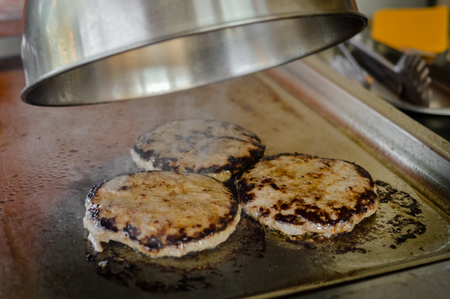 Burger on a stove background. Cooking delicious hamburger cheeseburger. Healthy fresh food hot heat for eatingの写真素材