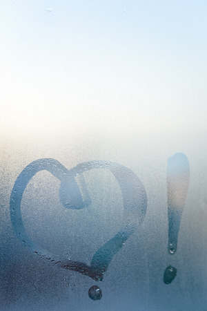Love heart symbol on a wet misted blurred glass textured background. Creative emotional happiness romance valentines feeling abstractionの写真素材