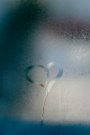 Love heart symbol on a wet misted blurred glass textured background. Creative emotional happiness romance valentines feeling abstractionの写真素材