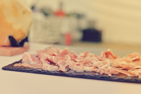 Prosciutto or jamon serrano. Close up on cutting traditional Italian Spanish ham. Slicing prepared hamon gastronomy backgroundの写真素材