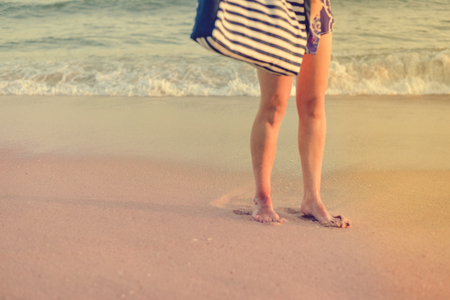 Closeup on female legs by the beach shore outdoors tranquil nature background. Active person walking by coastline, healthy beauty free leisure aspiration lifestyle sceneの写真素材