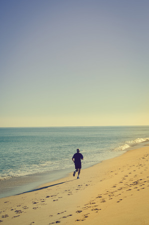 Unrecognized active sporty people happy running on the beach ecean shore sunny day outdoors background, vitality healthy motion lifestyle activityの写真素材