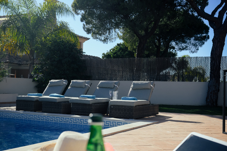 Mobile phone by the pool on sunny background. Modern holiday luxury recreation lifestyle