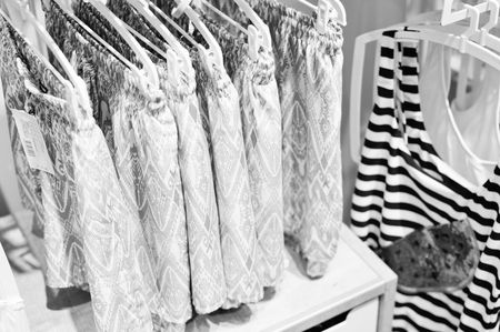 Close up on clothing hanger hanging on rail over busy shopping lifestyle background. Modern consumerism, buying, spending trend and marketing solutionの写真素材