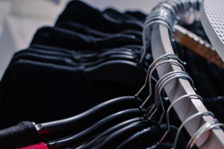 Close up on clothing hanger hanging on rail over busy shopping lifestyle background. Modern consumerism, buying, spending trend and marketing solutionの写真素材