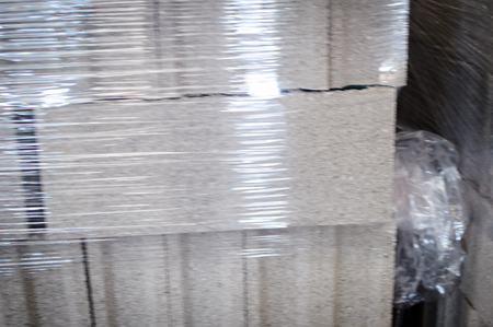 Motion blur image of cement building blocks stacked piled in warehouse background, closeup fabric plant manufacture grey textured abstract surfaceの写真素材