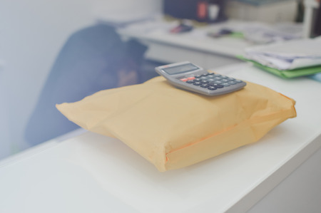 Closeup on letter craft envelope on the office background. Receiving and sending commercial or personal package, top side view communication conceptual designの写真素材