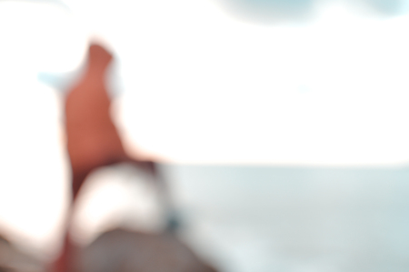 Back view of defocused silhouette, unrecognisable person on seaside coastal beauty natural background. Active human and freedom adventure lifestyle, nature scenic walk, relaxing sunlight glowの写真素材