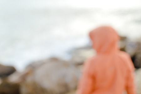 Back view of defocused silhouette, unrecognisable person on seaside coastal beauty natural background. Active human and freedom adventure lifestyle, nature scenic walk, relaxing sunlight glowの写真素材
