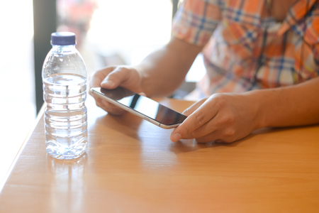 Mockup top side view image of mobile phone with blank screen on wooden table background, close up copy space communicationの写真素材