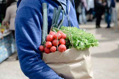 Close up on person buyer hold groceries in bags. Buy sell vegetables. Healthy wellbeing lifestyle backgroundの写真素材
