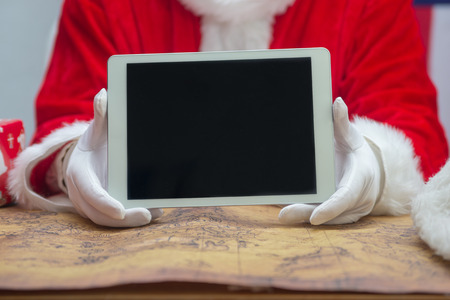 Santa Claus holding a tablet with blank space backgroundの写真素材