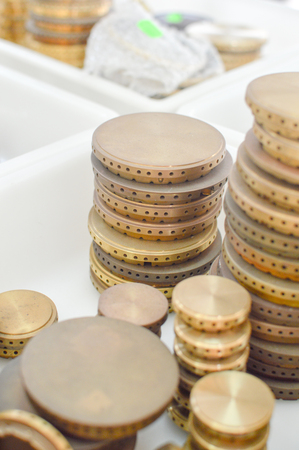 Gas plates spare parts for cooker, product shopping display background. Closeup on golden and gray shiny round shape elements of household applianceの写真素材