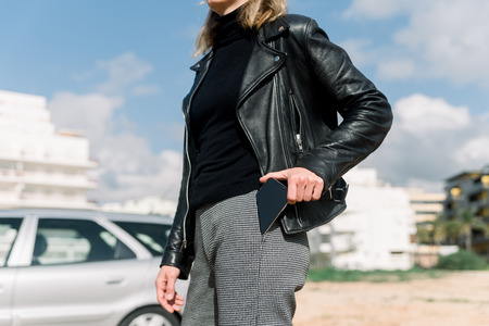 Woman using a mobile phone on car background, closeup image of social media, communication...