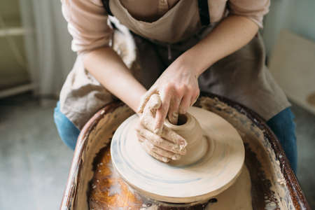 Girl working at potter's wheel closeup.の写真素材