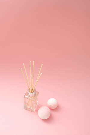 Set of spa supplies with bath bombs and aroma diffuser on pink background