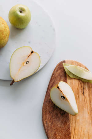 Pears and an apple with marble and wooden boards. Top view.の写真素材