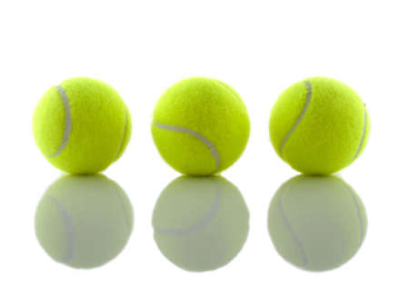 three tennis balls reflecting shadows on a mirrorの写真素材