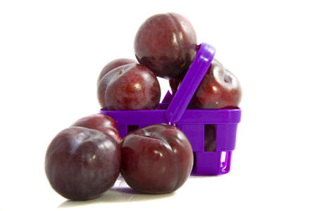 A basket filled with prunes isolated over whiteの写真素材
