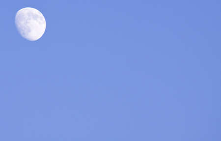 Moon in upper left corner by blue skiesの写真素材