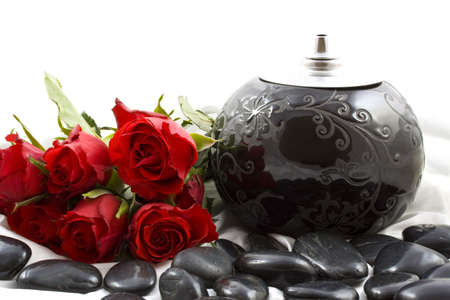 Black oil lamp on satin with roses and black stones on a white backgroundの写真素材