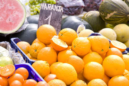 Oranges on a farmstand with lots of fruit on the backgroundの写真素材