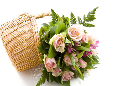 A bouquet with roses in a basket isolated over whiteの写真素材