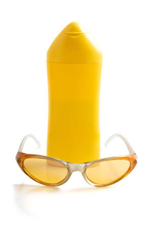 Yellow bottle with body milk and sun glasses isolated over whiteの写真素材