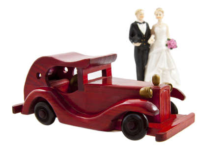 Married couple behind a red car isolated over whiteの写真素材