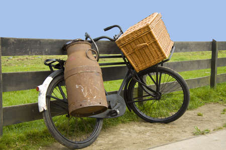 Old bike with milk can and bakery basketの写真素材