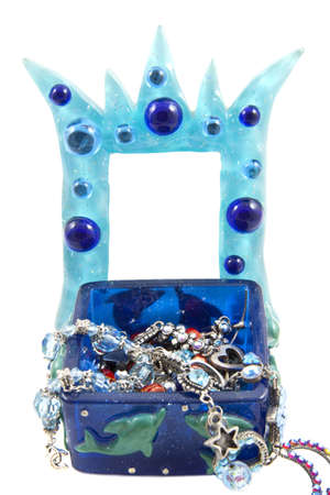 Blue crown frame with in front a box with jewels isolated over whiteの写真素材