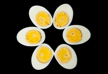 Six half eggs in a row isolated over blackの写真素材
