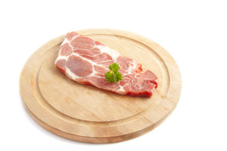 Pork chop on wooden plate isolated over whiteの写真素材