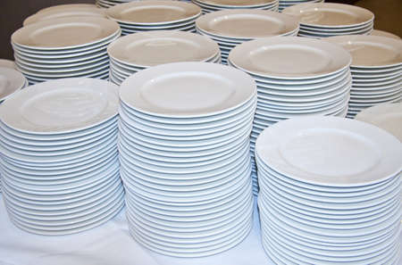 Many white plates on a pile for background useの写真素材