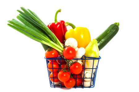 Shopping basket filled with vegetables isolated over whiteの写真素材